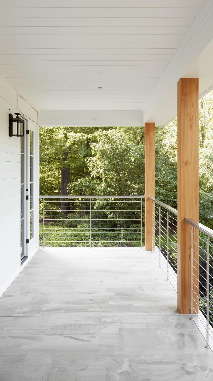 Modern horizontal cable porch railing with natural wood posts and open garden view